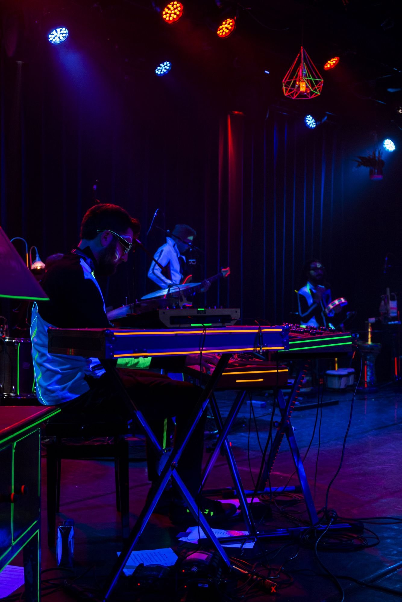 Out Of Nations performing on stage, backlit